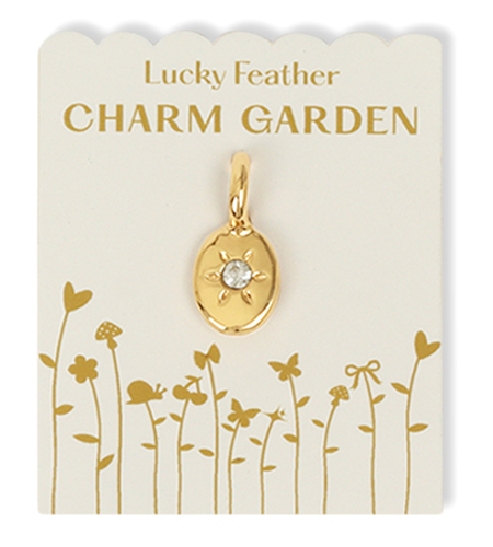 A gold 'Lucky Feather Charm Garden' charm on a card with a plant design.
