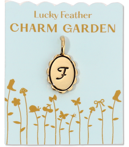 A gold charm with the letter 'F' on a card that reads 'Lucky Feather Charm Garden.'