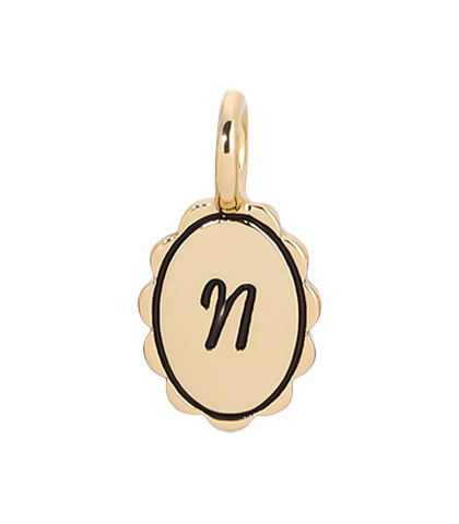 A gold charm with the letter 'n' in black.