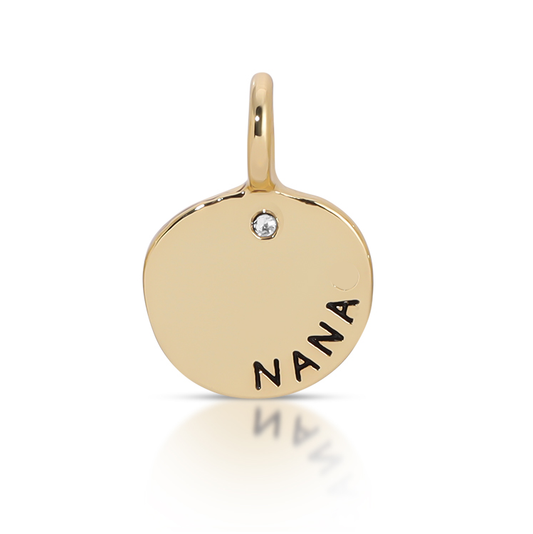 A gold charm with the word 'NANA' and a small clear stone.