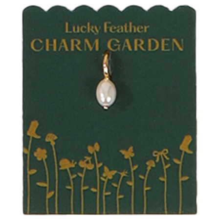 A pearl charm on a 'Lucky Feather Charm Garden' card with gold flower illustrations.