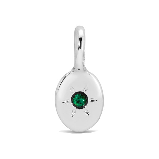 Close-up of a silver pendant with a green gem.