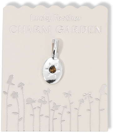 Silver charm pendant with a brown stone on a 'Lucky Feather Charm Garden' card with silver flower designs.
