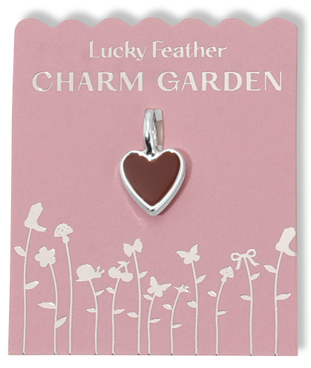A heart-shaped charm is displayed on a pink card with silver text and floral designs.