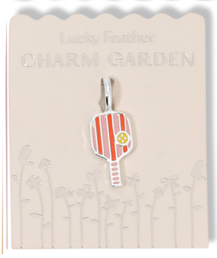 A pickleball paddle charm hangs from a beige card with 'Lucky Feather CHARM GARDEN' printed on it.