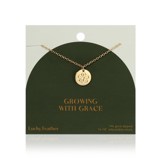 A gold flower pendant necklace from Lucky Feather, presented on its display card.