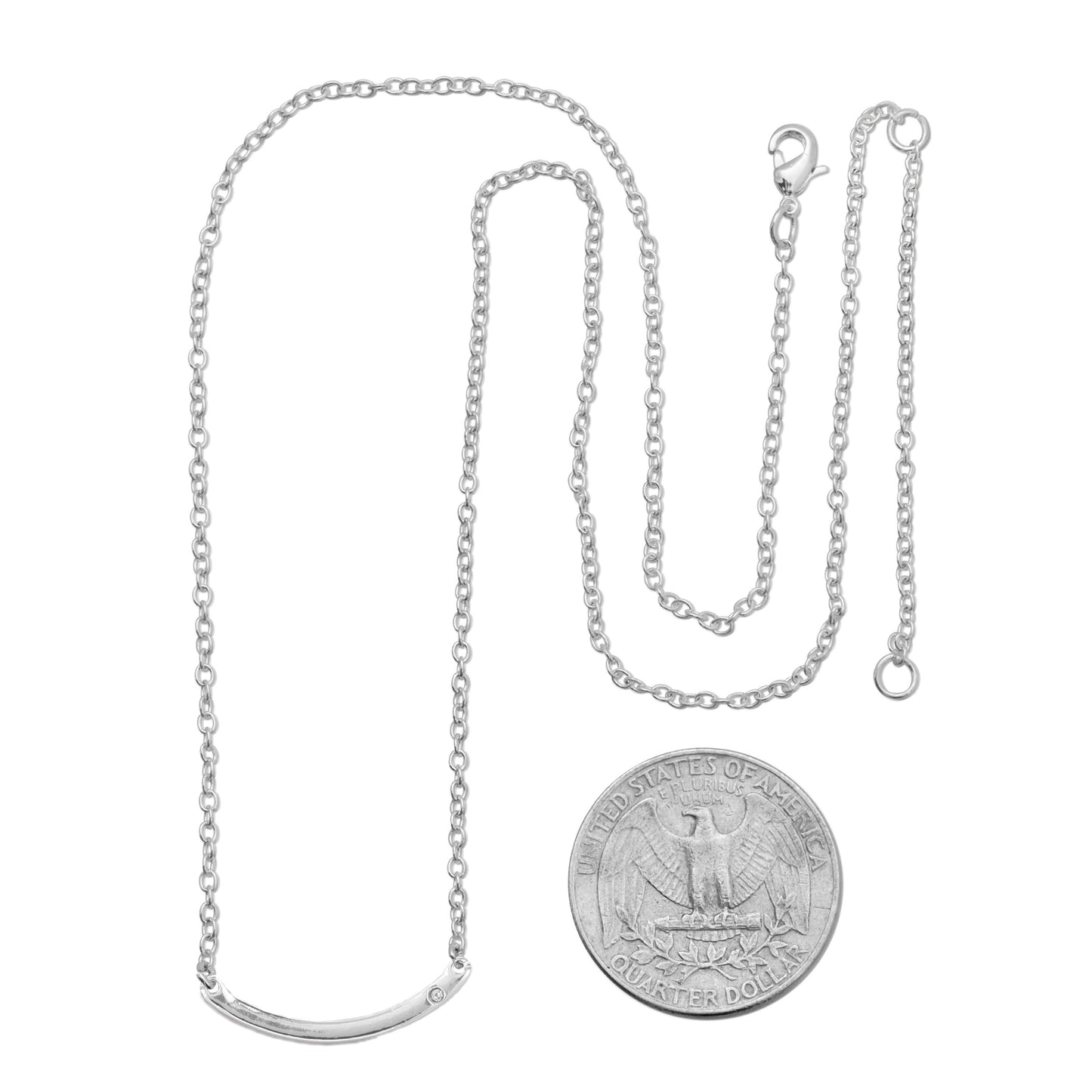 A silver chain necklace with a curved bar pendant sits next to a US quarter.