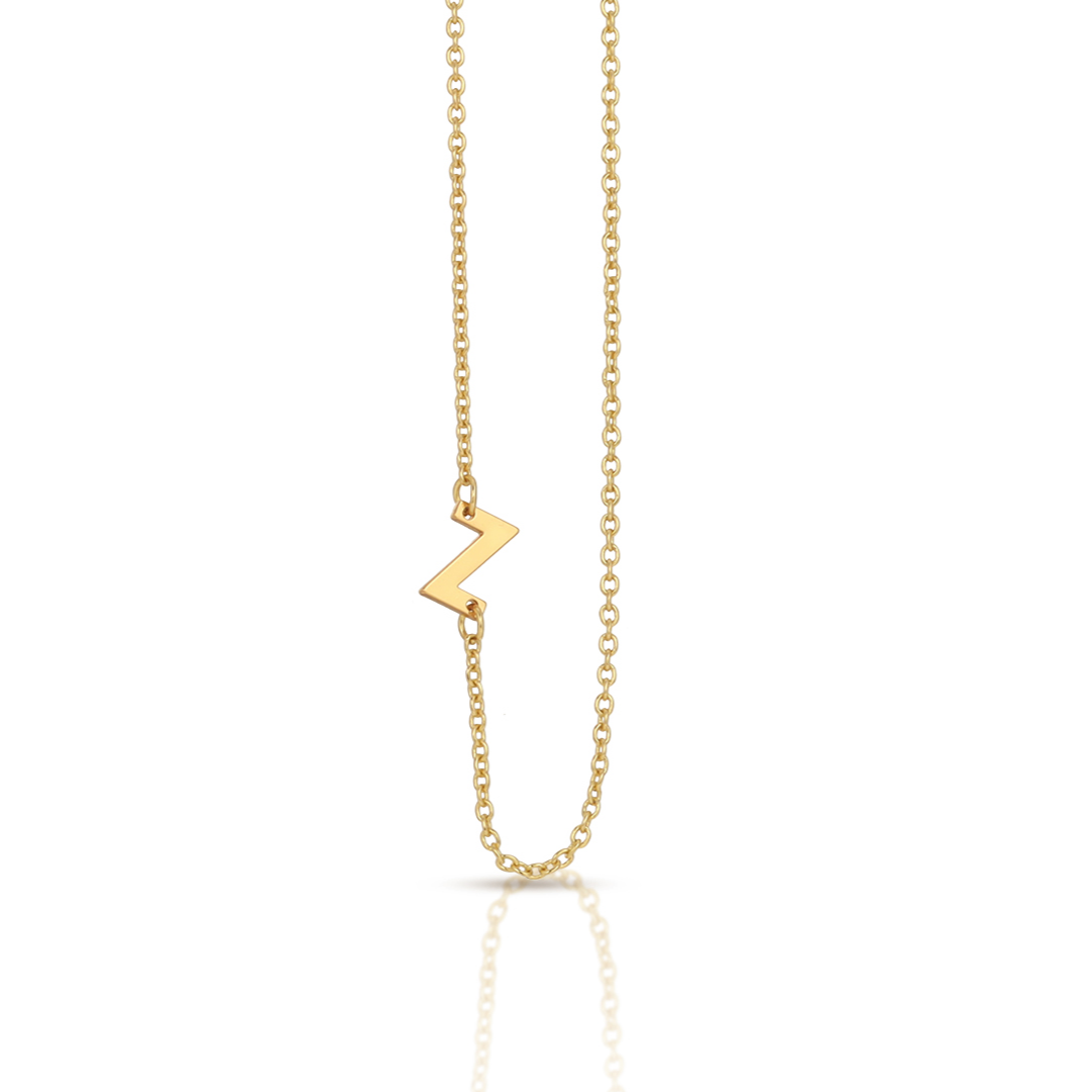 A gold chain necklace features a sideways 'Z' pendant.
