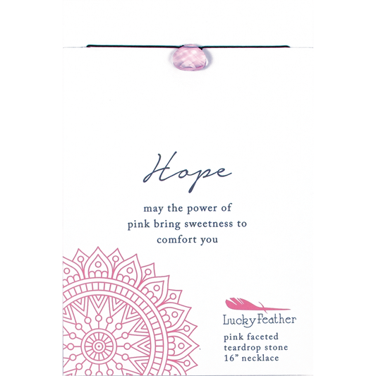 Close-up of a necklace with a pink faceted teardrop stone labeled 'Hope' on a card with inspirational text.