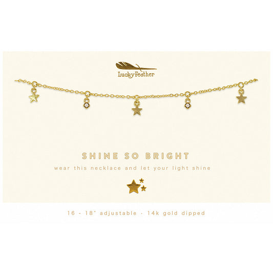 A gold-colored chain necklace with star and gem pendants, displayed on a card that says 'Shine So Bright'.