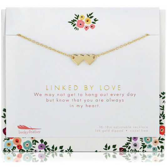 A gold necklace with two small heart pendants is displayed on a card with floral accents and the text 'Linked by Love'.