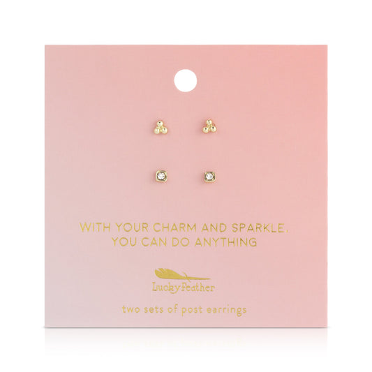 Two sets of stud earrings are displayed on a pink card with gold lettering that says 'Lucky Feather' and an inspirational phrase.