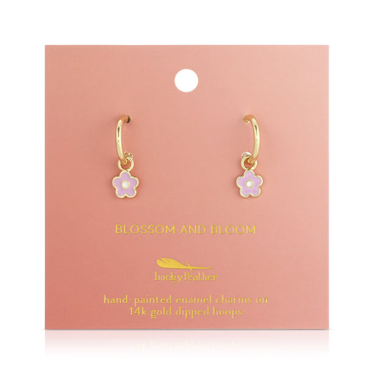 Gold hoop earrings with pink and white flower charms on a pink card.