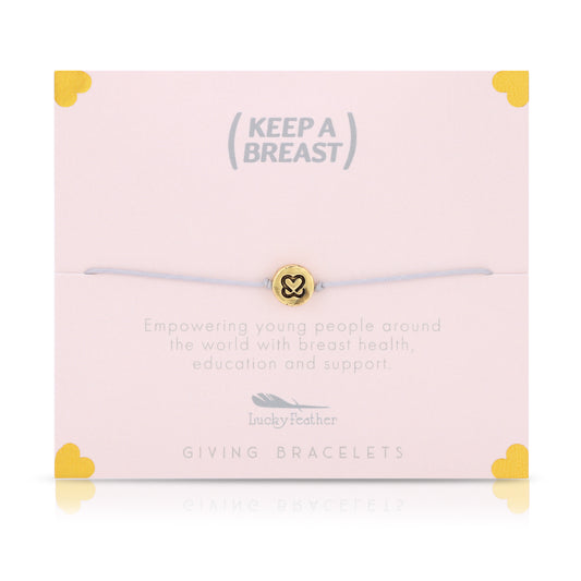 A bracelet with a gold charm sits on a pink card with the text 'Keep A Breast,' along with details on breast health education and support.