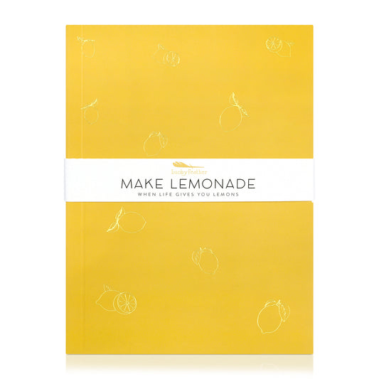 A yellow notebook with lemon outlines and a white band that reads 'Make Lemonade' and 'When Life Gives You Lemons'.