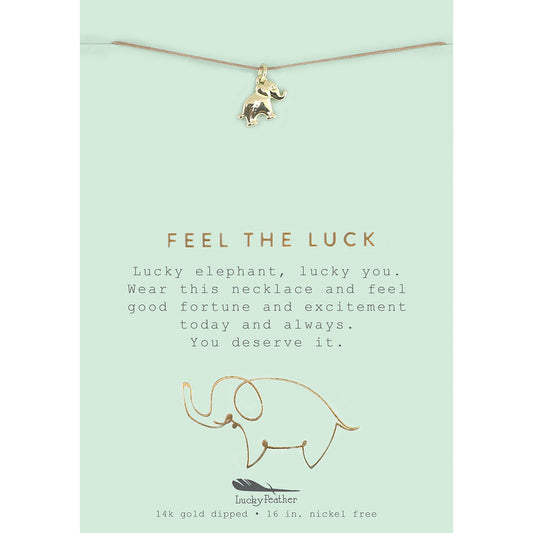 A lucky elephant necklace hangs on a card with the words 'Feel the Luck.'