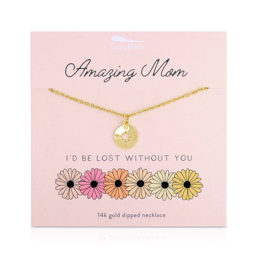 A gold compass necklace on a pink display card with the words 'Amazing Mom' and 'I'd Be Lost Without You'.